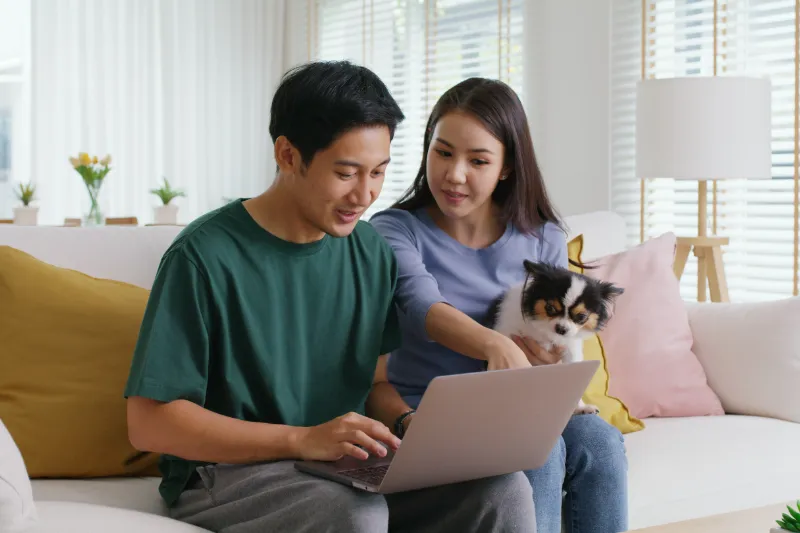 Couple sitting on couch looking at laptop